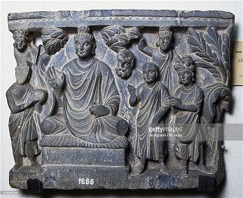 Buddha sitting under a tree with his devotees by his side